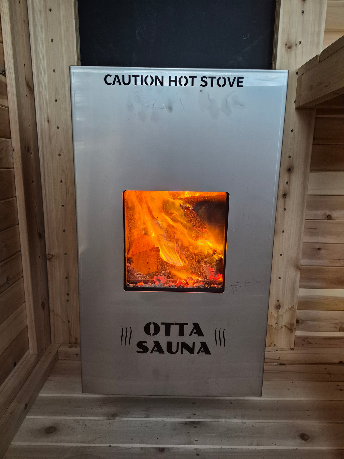 Exterior fed wood sauna stove