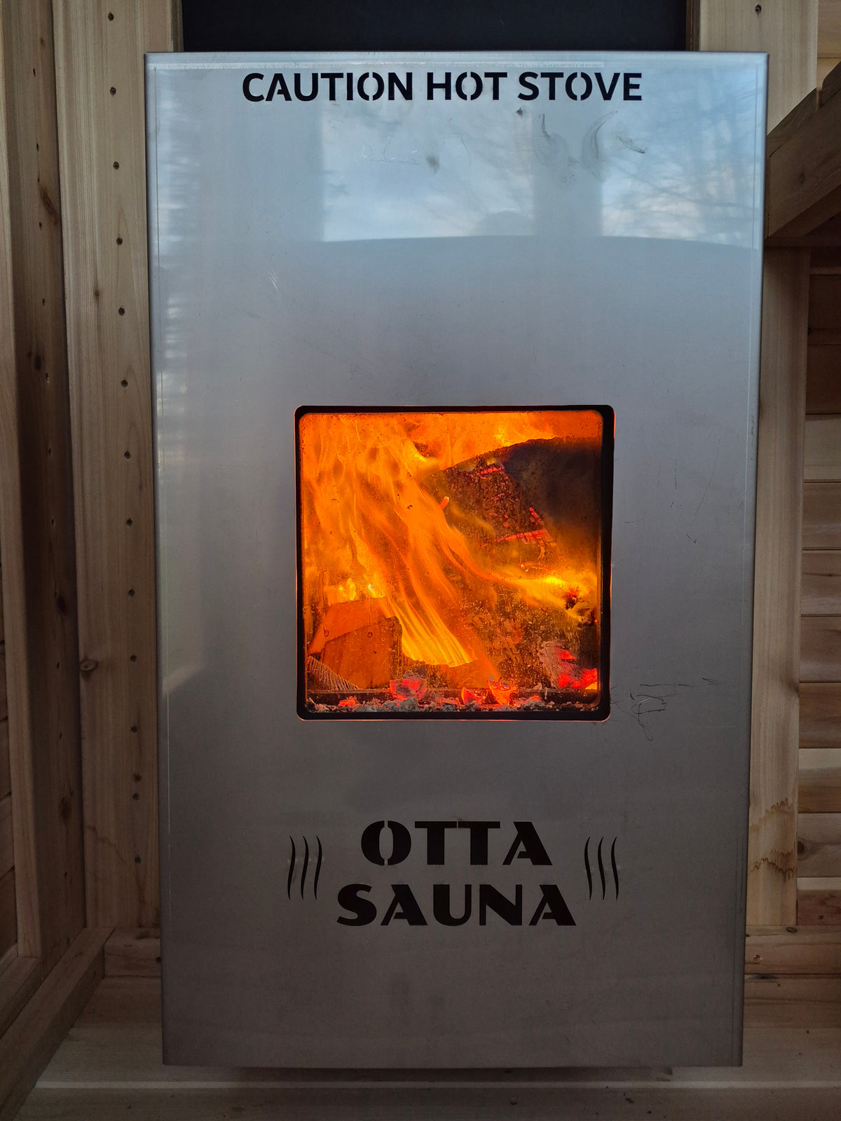 Exterior fed wood sauna stove